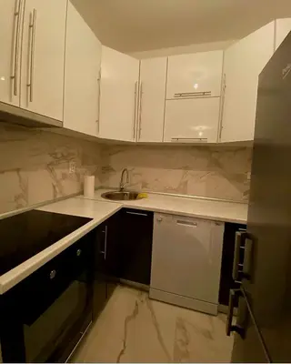a kitchen with white cabinets and a sink at Stan na dan Banja luka Mejdan in Hiseti