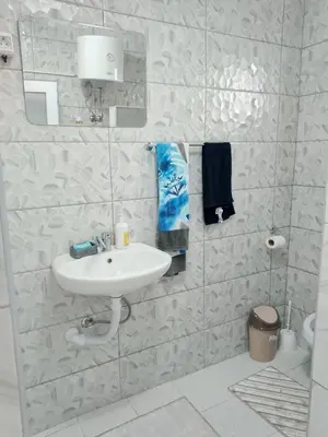 a white bathroom with a sink and a mirror at Apartmani Amina in Bihać