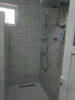 a bathroom with a shower with a glass door at Apartmani Amina in Bihać
