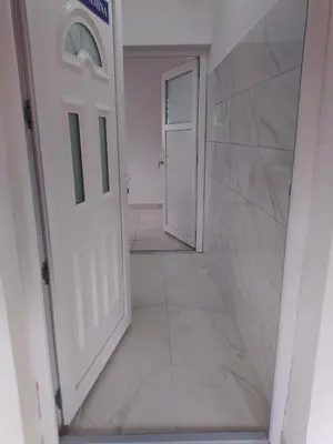 a hallway with two white doors and a tile floor at Apartmani Amina in Bihać