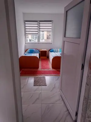 a small room with two beds and a window at Apartmani Amina in Bihać