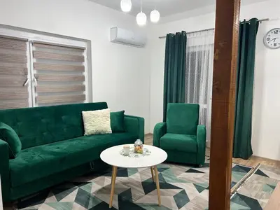 a living room with a green couch and two chairs at Apartman Mrša in Livno