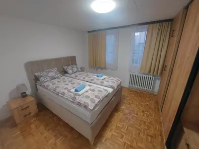 a bedroom with a bed with a wooden floor at Apartman Borik in Banja Luka