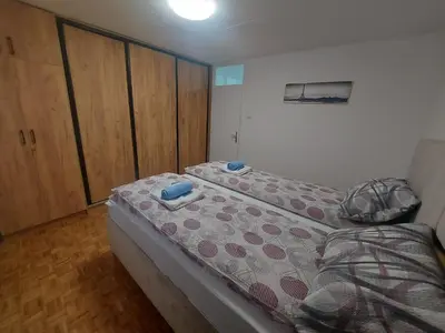 a small bedroom with a bed and wooden floors at Apartman Borik in Banja Luka