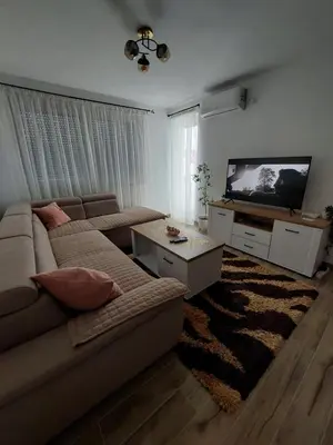 a living room with a couch and a flat screen tv at Apartman Aurora in Modriča