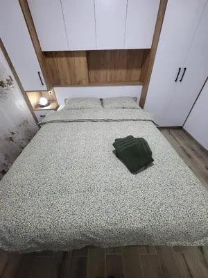 a bed in a room with a green pillow on it at Apartman Aurora in Modriča