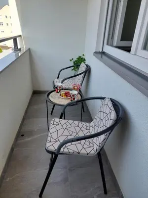 a pair of chairs and a table on a balcony at Apartman Aurora in Modriča