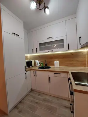 a kitchen with white cabinets and a sink at Apartman Aurora in Modriča