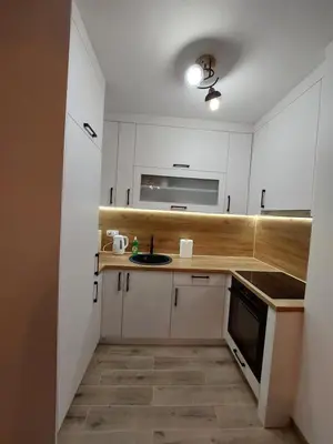 a small kitchen with white cabinets and a sink at Apartman Aurora in Modriča