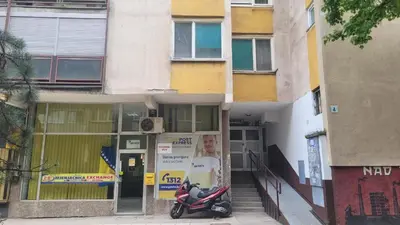 a scooter parked in front of a building at City Center Moku Apartman in Zenica