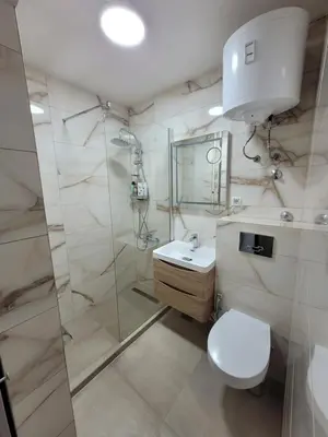 a bathroom with a toilet and a sink and a shower at City Center Moku Apartman in Zenica