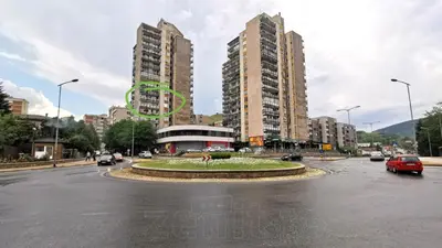 a city with tall buildings and a street with cars at City Center Moku Apartman in Zenica
