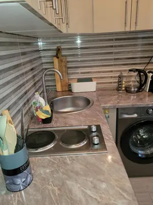 a kitchen counter top with a sink and a sink at City Center Moku Apartman in Zenica