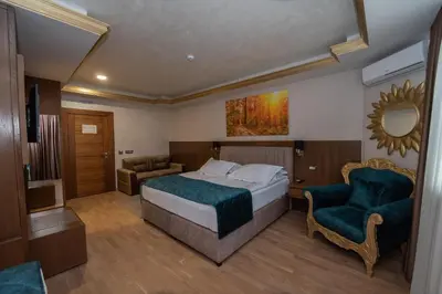 a hotel room with a bed and a chair at Hotel Park in Srebrenik