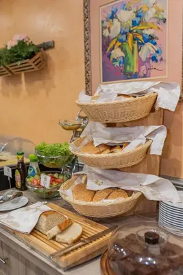 a counter with baskets of bread and other foods at Hotel Park in Srebrenik