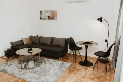 a living room with a couch and a table and chairs at Apartman at 8th in Banja Luka