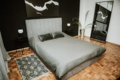 a bedroom with a bed and two tables and a mirror at Apartman at 8th in Banja Luka