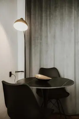 a table with two chairs and a lamp and a bowl on it at Apartman at 8th in Banja Luka