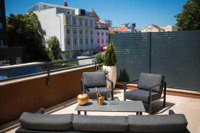 a balcony with two chairs and a couch and a table at Ideal Apartments in Banja Luka