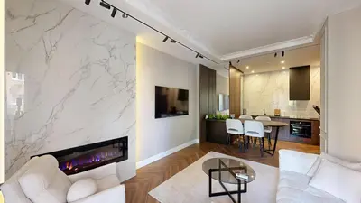 a living room with a fireplace and a white couch at Ideal Apartments in Banja Luka