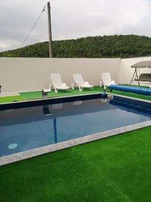 a swimming pool with chairs and a table and a table at Halal Holidey Kuća za odmor in Spahići