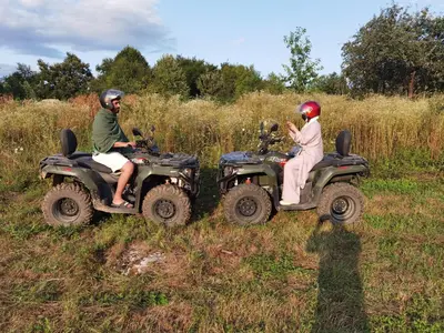 a man and woman riding on atvs in a field at Halal Holidey Kuća za odmor in Spahići