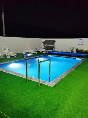 a large swimming pool with green grass around it at Halal Holidey Kuća za odmor in Spahići