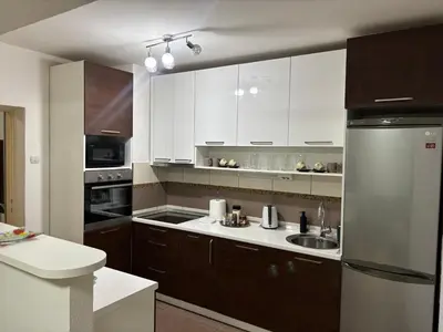 a kitchen with white cabinets and a stainless steel refrigerator at Apartman Centar in Banja Luka