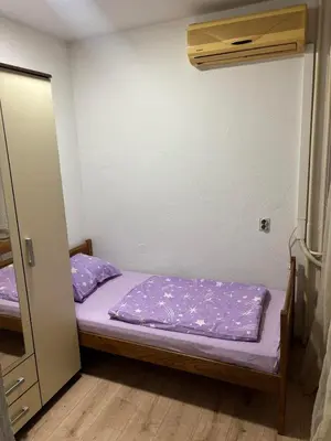 a small room with a bed with purple sheets at Apartman Centar in Banja Luka