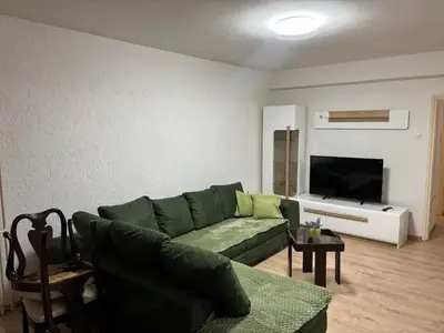 a living room with a green couch and a television at Apartman Centar in Banja Luka