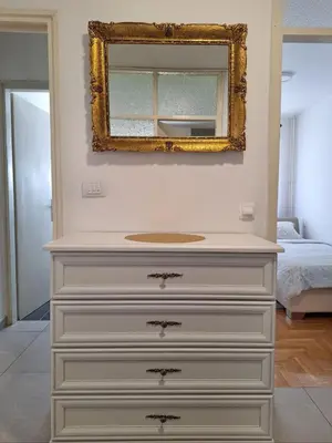 a white dresser with a mirror on top of it at Apartman Bulevar Banjaluka in Banja Luka