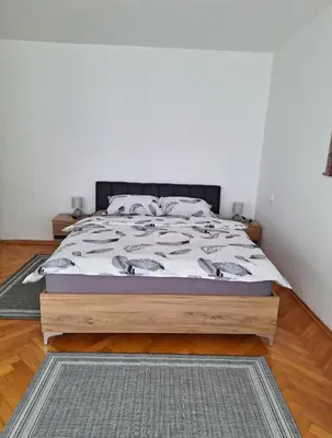a bedroom with a bed with a wooden bed frame at Apartman Bulevar Banjaluka in Banja Luka