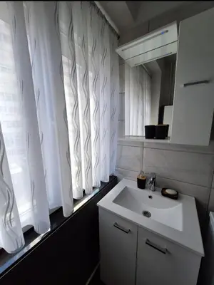 a bathroom with a white sink and a mirror at Apartman Bulevar Banjaluka in Banja Luka