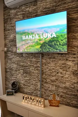 a flat screen tv on a brick wall at Apartman Atrium Banja Luka in Banja Luka
