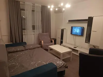 a living room with a couch and a tv at City apartmant in Tuzla