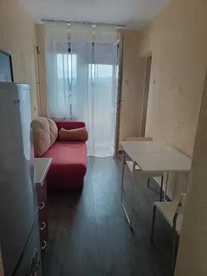 a living room with a red couch and a table at City apartmant in Tuzla
