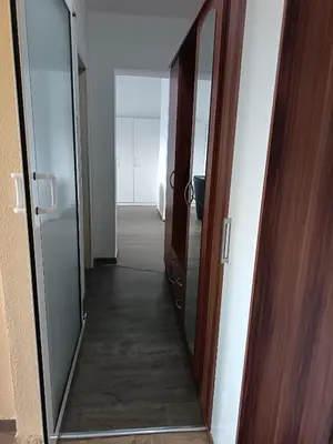 a hallway with two glass doors and a mirror at City apartmant in Tuzla