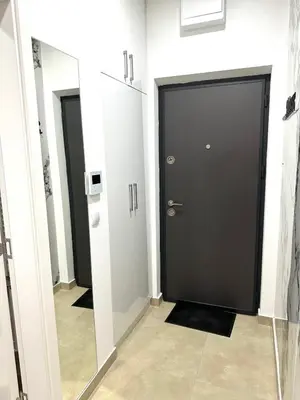 a hallway with black doors and white walls at Apartman Most in Bosanska Gradiška