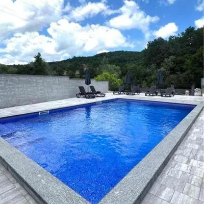 a large blue swimming pool with chairs and a wall at Villa Imperia for rent - Banja Luka Krupa na Vrbasu in Krupa na Vrbasu