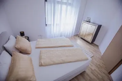 a white bed with two pillows on it in a room at Apartman Eden Bihać in Bihać