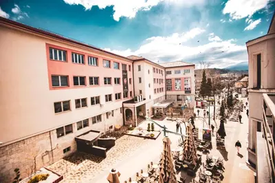 a city street with buildings and people walking around at Apartman Eden Bihać in Bihać