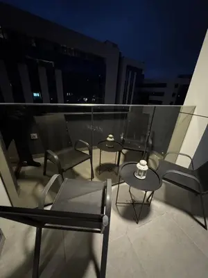 three chairs and tables on a balcony at night at Apartman DK VIII in Banja Luka
