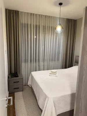 a bedroom with a white bed and a window at Apartman AK IX in Banja Luka