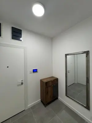 a white room with a mirror and a wooden dresser at Apartman AK IX in Banja Luka