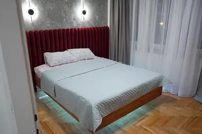 a bedroom with a bed and a red radiator at Apartman Bosiljak in Banja Luka
