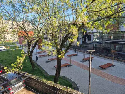 a group of benches in a park next to a building at Apartman Bosiljak in Banja Luka