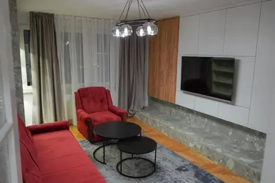 a living room with a red couch and a red chair at Apartman Bosiljak in Banja Luka