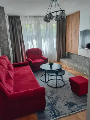 a living room with a red couch and a table at Apartman Bosiljak in Banja Luka
