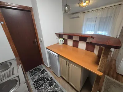 a small kitchen with a counter and a sink at Apartman Sanus in Sanski most