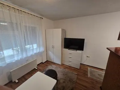a living room with a television and a white cabinet at Apartman Sanus in Sanski most